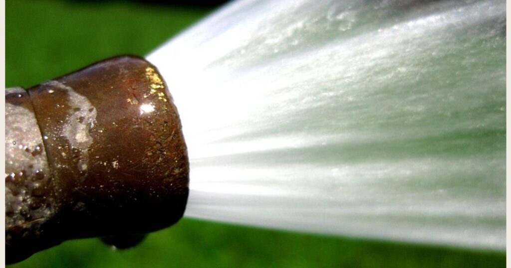 Water spraying from the end of a garden hose